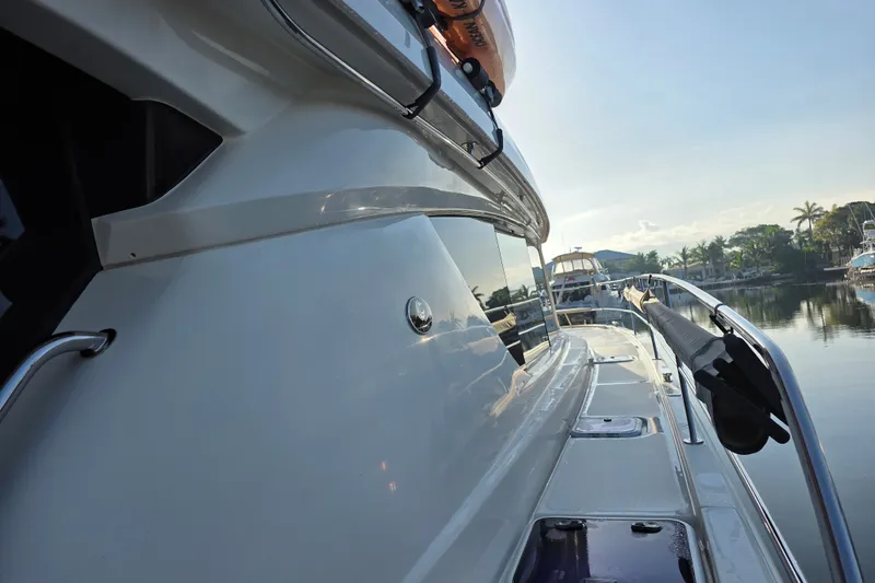 Slide: The Image of Side view of a 2016 Aquila 48 yacht docked by a serene waterfront. - 2