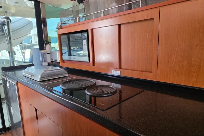 Slide: The Image of Modern kitchen on 2016 Aquila 48 yacht with stove, microwave, and wooden cabinetry. - 18