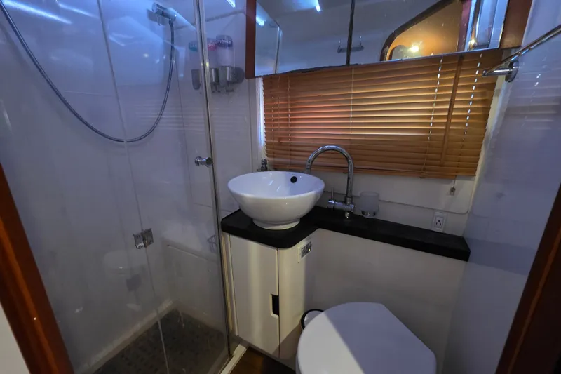 Slide: The Image of Modern bathroom in 2016 Aquila 48 yacht with shower, sink, and wooden blinds. - 22