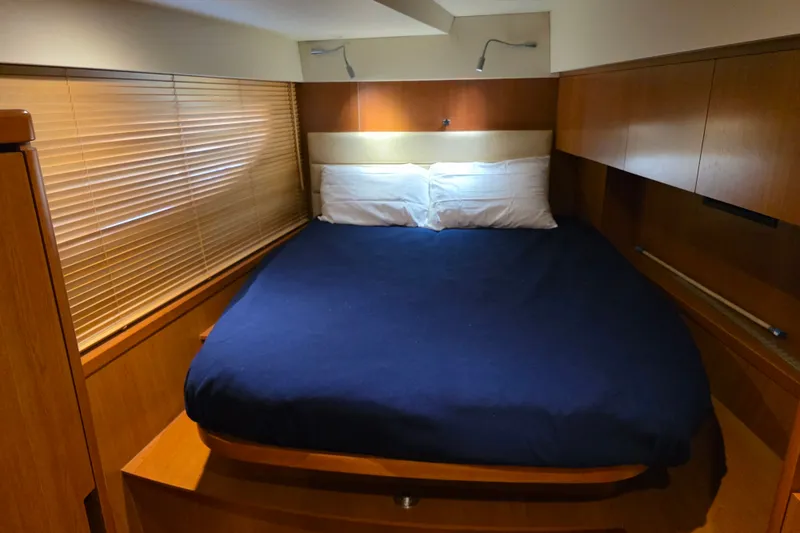 Slide: The Image of Cozy bedroom interior of 2016 Aquila 48 yacht with wooden accents and blue bedding. - 21