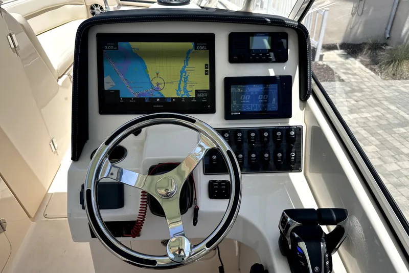 Slide: The Image of Helm of 2021 Grady-White Freedom 275 boat with navigation and control systems. - 15