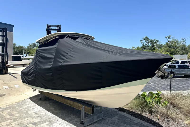 Slide: The Image of 2021 Grady-White Freedom 275 boat covered, parked outdoors on a sunny day. - 18