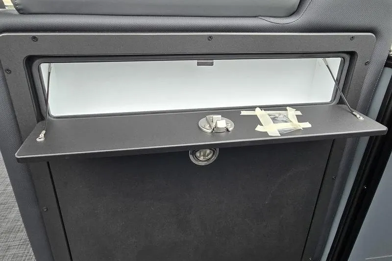 Slide: The Image of Storage compartment in a 2026 Godfrey Sweetwater 2286 SB boat, featuring a secure latch. - 9