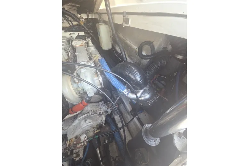 Slide: The Image of Engine compartment of a 2001 Pursuit 3000 Offshore boat, showing various components and hoses. - 11