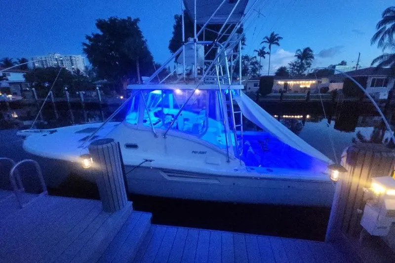 Slide: The Image of 2001 Pursuit 3000 Offshore boat docked at night with blue interior lighting. - 4