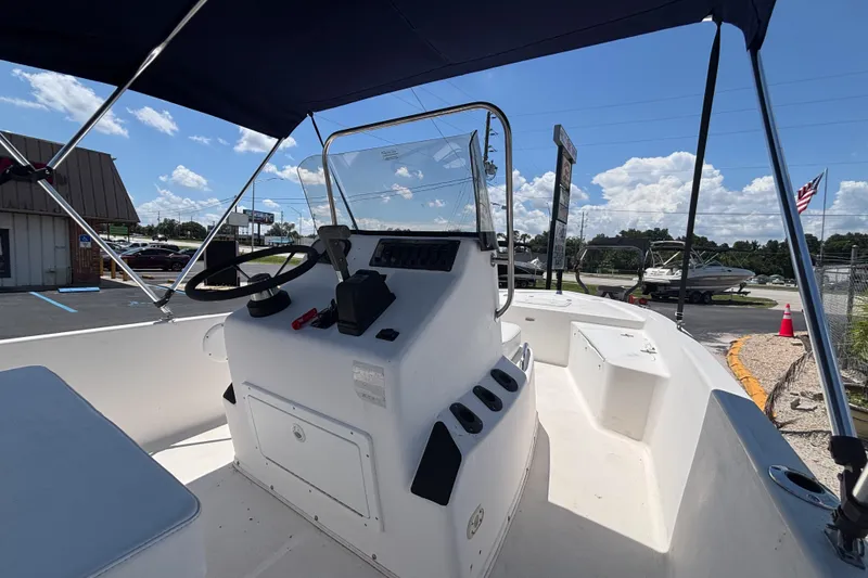 Slide: The Image of 2001 Century 1900 Inshore boat interior with steering console under blue sky. - 14