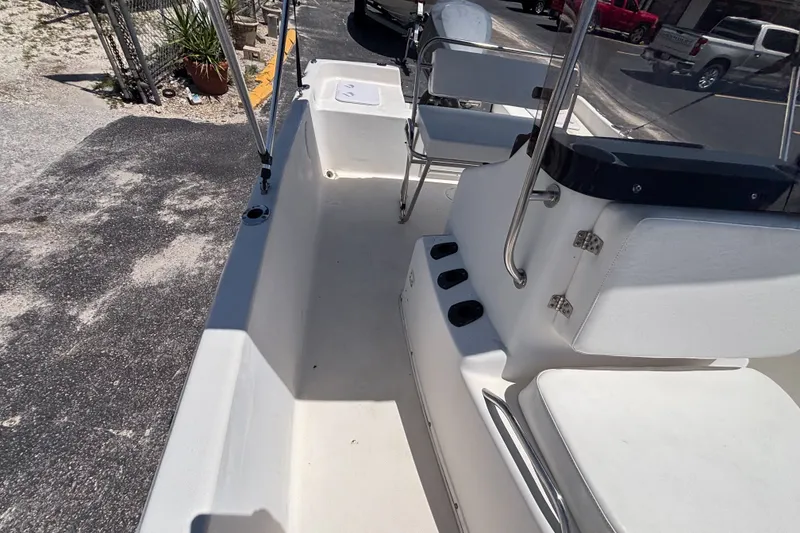 Slide: The Image of Century 1900 Inshore 2001 boat interior with seating and console, parked on pavement. - 26