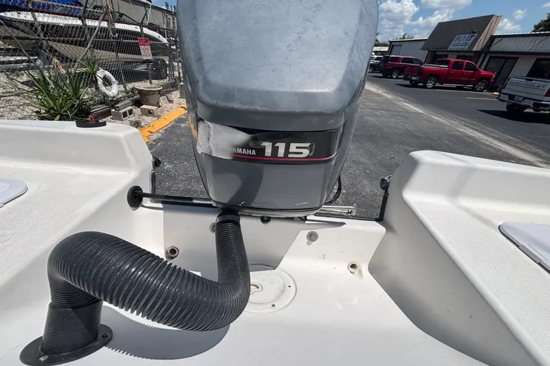 Slide: The Image of Century 1900 Inshore boat with Yamaha 115 outboard motor, parked outdoors. - 18