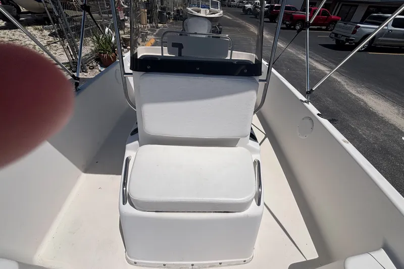 Slide: The Image of Century 1900 Inshore 2001 boat interior with white seating and console, parked outdoors. - 25