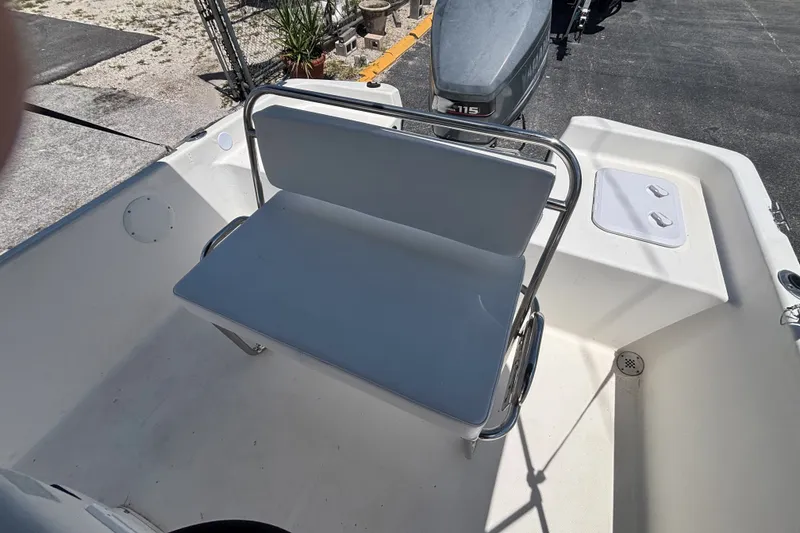 Slide: The Image of Century 1900 Inshore 2001 boat interior with seating and motor, docked outdoors. - 17