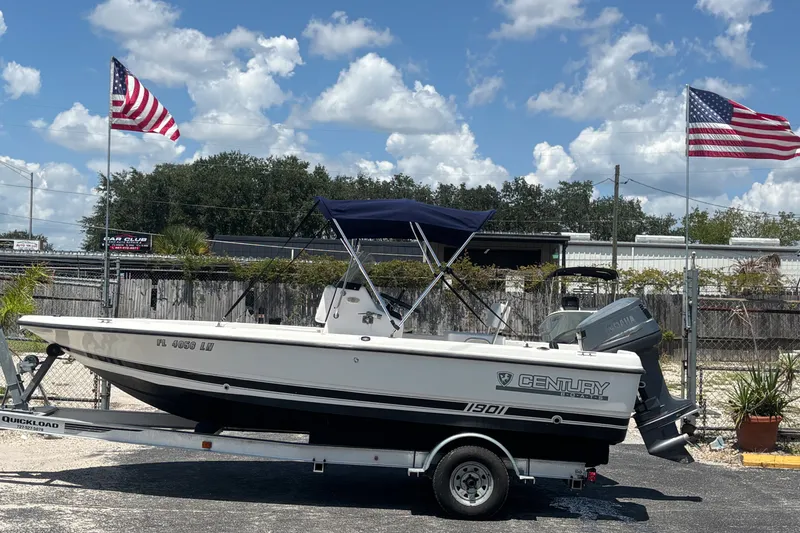 The Image of Century 1900 Inshore boat on trailer, American flags, clear sky background. - 1