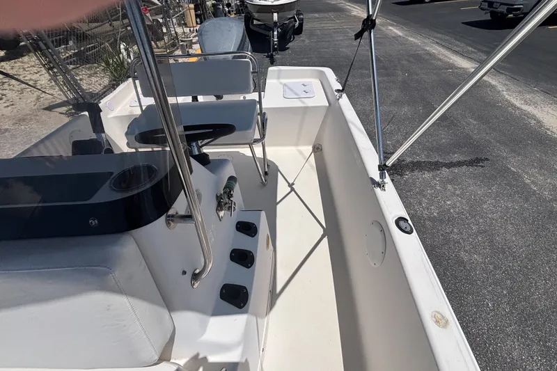 Slide: The Image of Century 1900 Inshore 2001 boat interior with seating and console, parked on asphalt. - 27