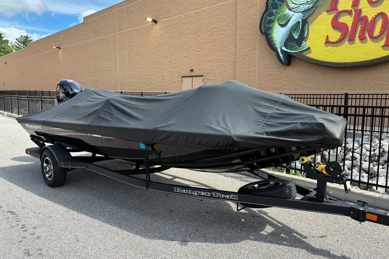 Slide: The Image of 2023 Ranger RT188 boat covered on a trailer outside a store. - 20