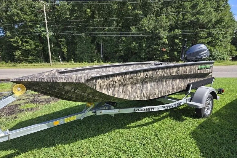 The Image of 2026 Havoc 1553 VJST boat on trailer, camo design, parked on grass. - 0