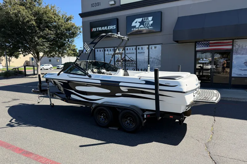 Slide: The Image of 2004 MB B-52 boat on trailer outside dealership, featuring sleek black and white design. - 3