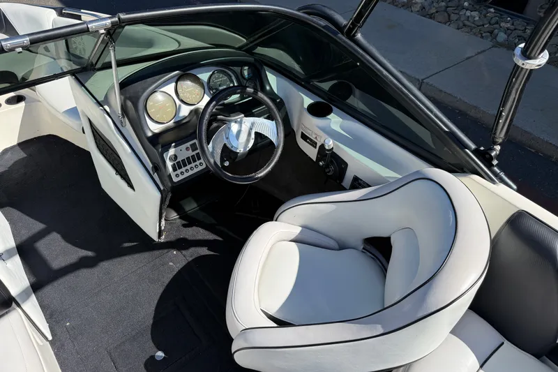 Slide: The Image of Interior of a 2004 MB B-52 boat with sleek dashboard and white seating. - 14