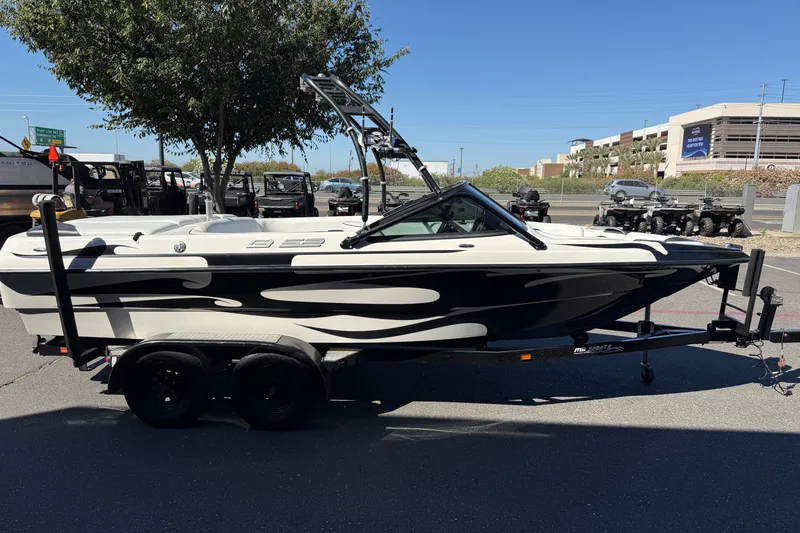 Slide: The Image of 2004 MB B-52 boat on trailer, parked outdoors, with black and white design. - 6