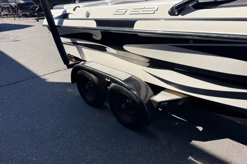 Slide: The Image of 2004 MB B-52 boat trailer with dual black wheels on pavement. - 11