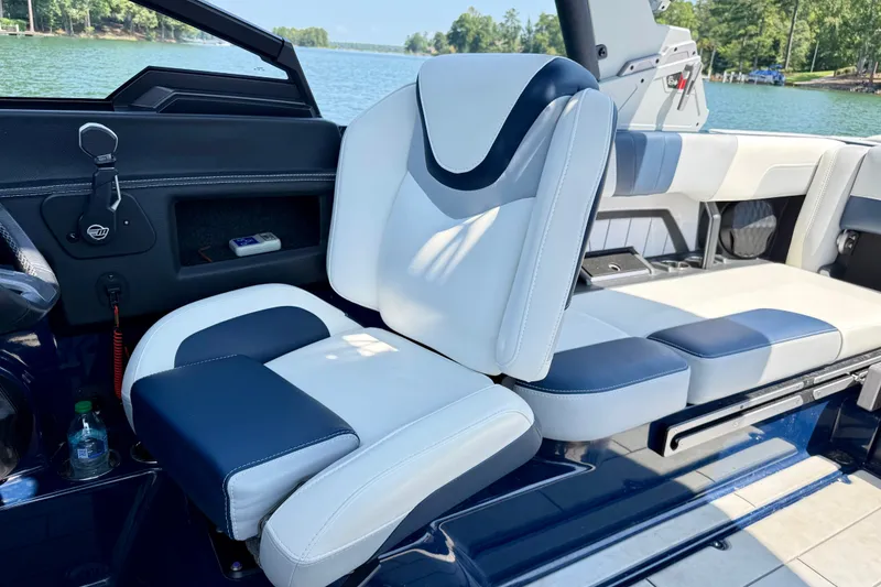 Slide: The Image of 2022 Malibu Wakesetter 23 MXZ interior with blue and white seating, lake view. - 12
