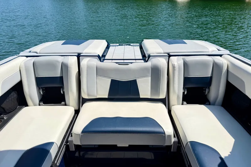Slide: The Image of 2022 Malibu Wakesetter 23 MXZ boat interior with stylish seating on a serene lake. - 23