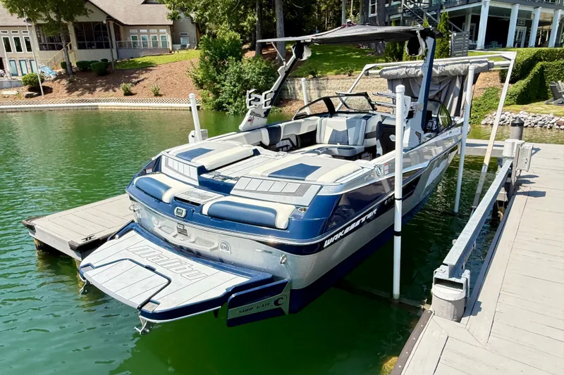 Slide: The Image of 2022 Malibu Wakesetter 23 MXZ boat docked on a serene lake. - 33