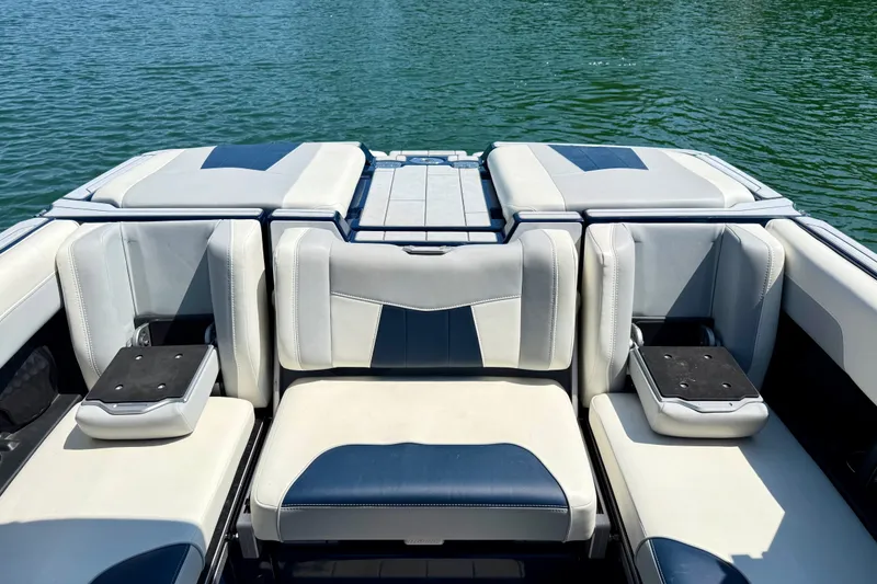 Slide: The Image of 2022 Malibu Wakesetter 23 MXZ boat interior with cushioned seating on a lake. - 24