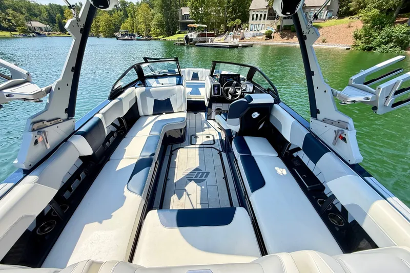 Slide: The Image of 2022 Malibu Wakesetter 23 MXZ boat interior with spacious seating on a serene lake. - 9