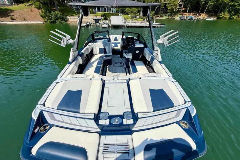 Slide: The Image of 2022 Malibu Wakesetter 23 MXZ boat on a serene lake, showcasing spacious seating and sleek design. - 8