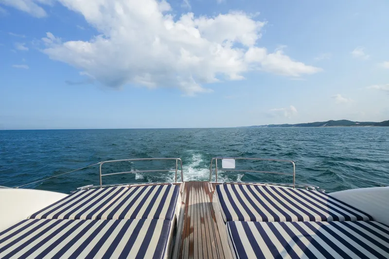 Slide: The Image of 2001 Viking Sport Cruisers V65 yacht deck with striped cushions, ocean view. - 12