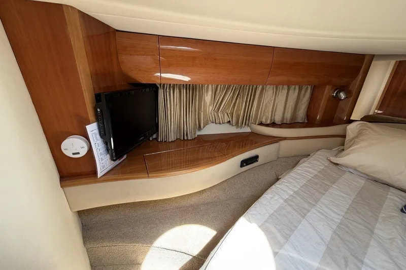 Slide: The Image of Interior cabin of 2001 Viking Sport Cruisers V65 with wood paneling and a mounted TV. - 49