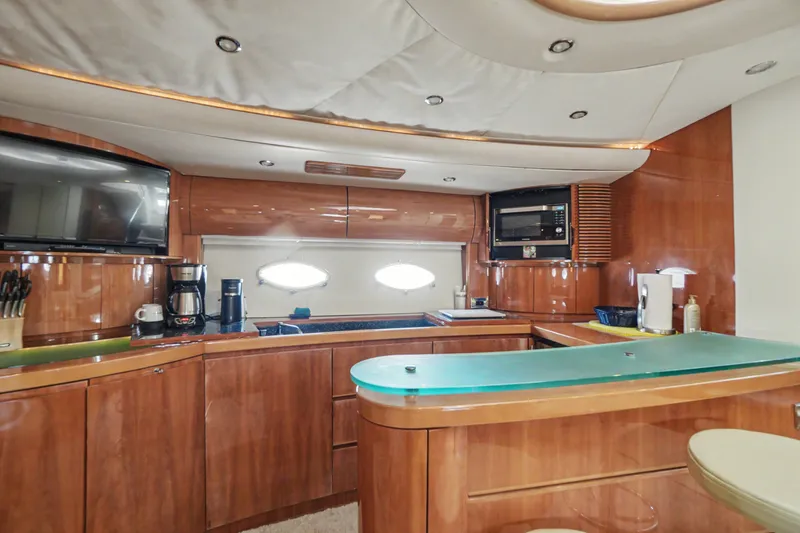 Slide: The Image of Luxurious 2001 Viking Sport Cruisers V65 yacht kitchen with modern amenities and elegant wood finish. - 40