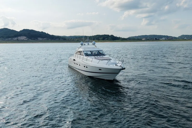 Slide: The Image of 2001 Viking Sport Cruisers V65 yacht cruising on serene waters under a cloudy sky. - 2
