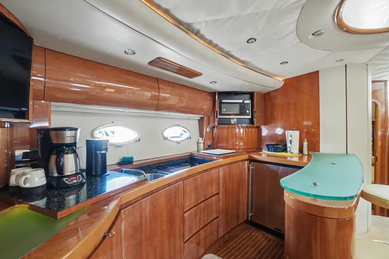 Slide: The Image of Luxurious 2001 Viking Sport Cruisers V65 yacht kitchen with modern appliances and elegant wood finish. - 42