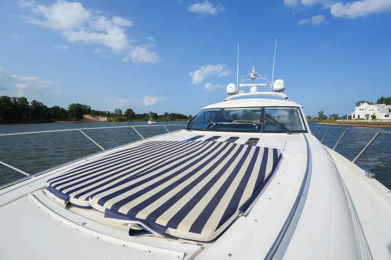 Slide: The Image of 2001 Viking Sport Cruisers V65 yacht on water, featuring striped deck cushion. - 21