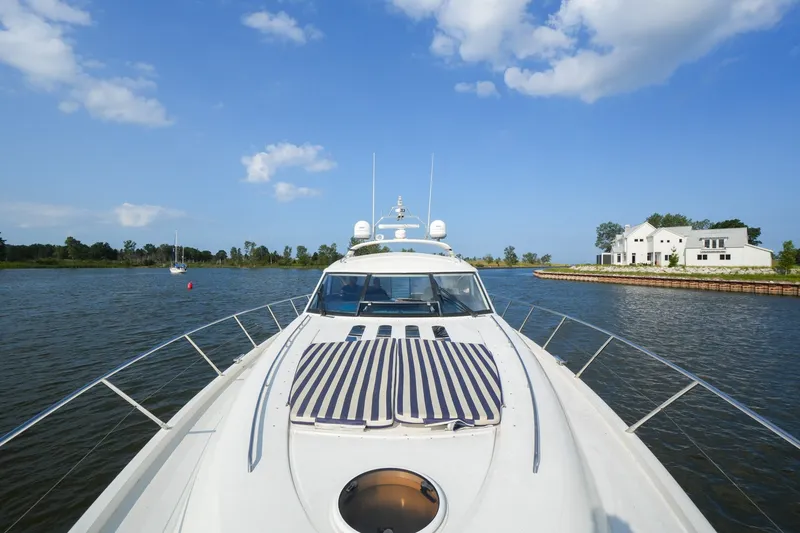 Slide: The Image of 2001 Viking Sport Cruisers V65 yacht cruising on a serene waterway under a clear blue sky. - 19