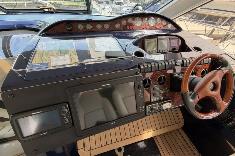 Slide: The Image of Cockpit of 2001 Viking Sport Cruisers V65 yacht with navigation equipment and wooden steering wheel. - 56