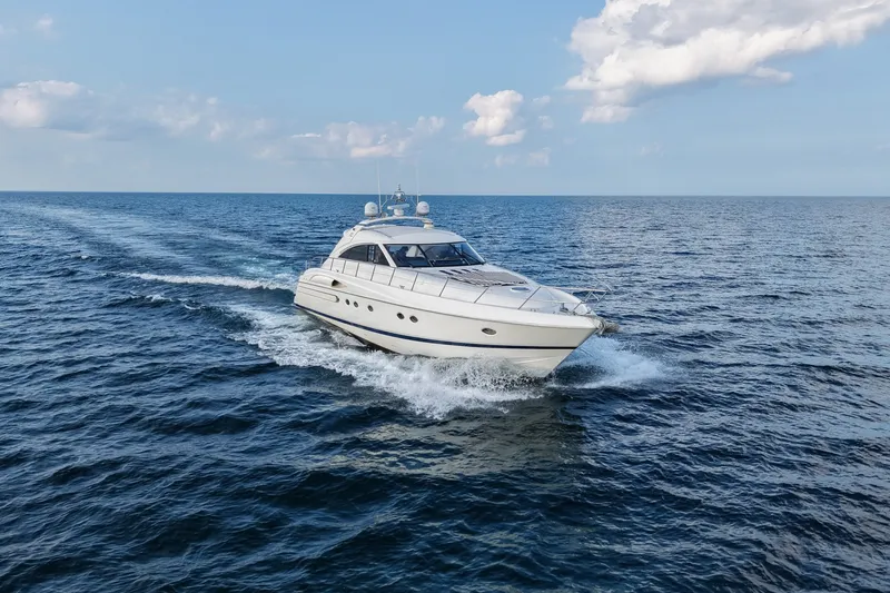 Slide: The Image of 2001 Viking Sport Cruisers V65 yacht cruising on open sea under blue sky. - 9