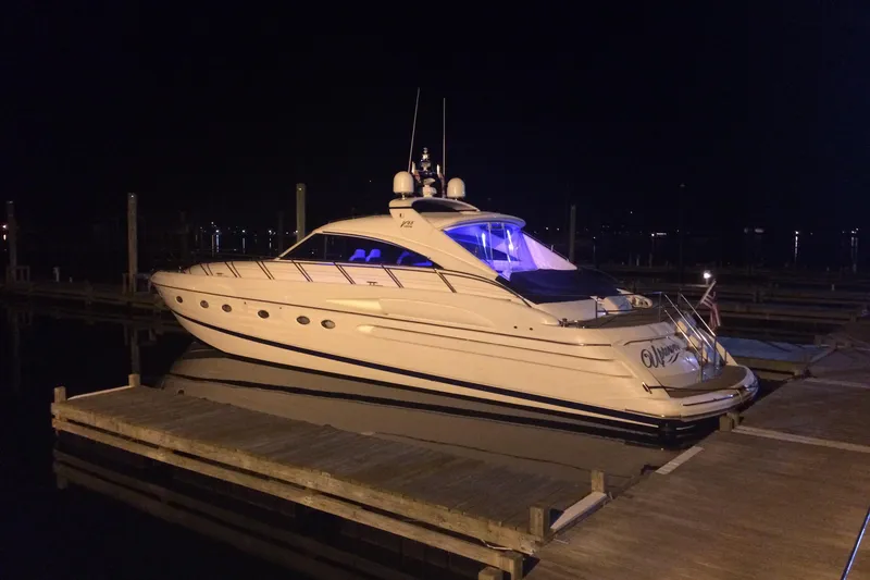 Slide: The Image of 2002 Viking Sport Cruisers V65 yacht docked at night with blue interior lighting. - 25