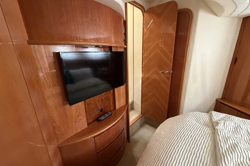 Slide: The Image of Luxurious cabin interior of 2001 Viking Sport Cruisers V65 with TV and wooden cabinetry. - 65