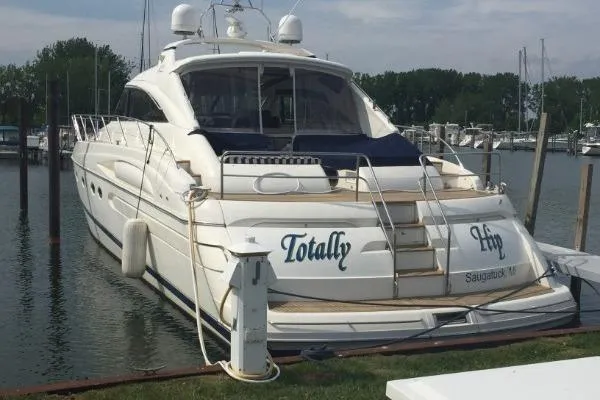 Slide: The Image of 2002 Viking Sport Cruisers V65 yacht docked at marina, named "Totally Hip." - 24