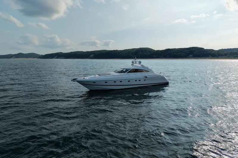 Slide: The Image of 2001 Viking Sport Cruisers V65 yacht cruising on serene waters under a partly cloudy sky. - 1