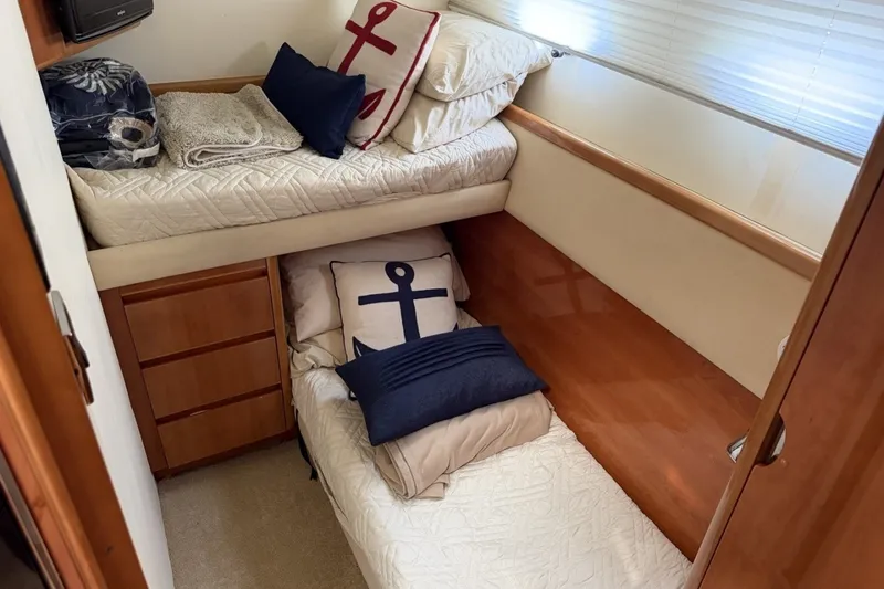 Slide: The Image of Cozy cabin interior of 2001 Viking Sport Cruisers V65 with nautical-themed bedding. - 58