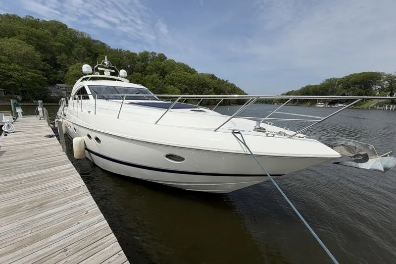 Slide: The Image of 2001 Viking Sport Cruisers V65 yacht docked by a wooden pier on a calm river. - 51