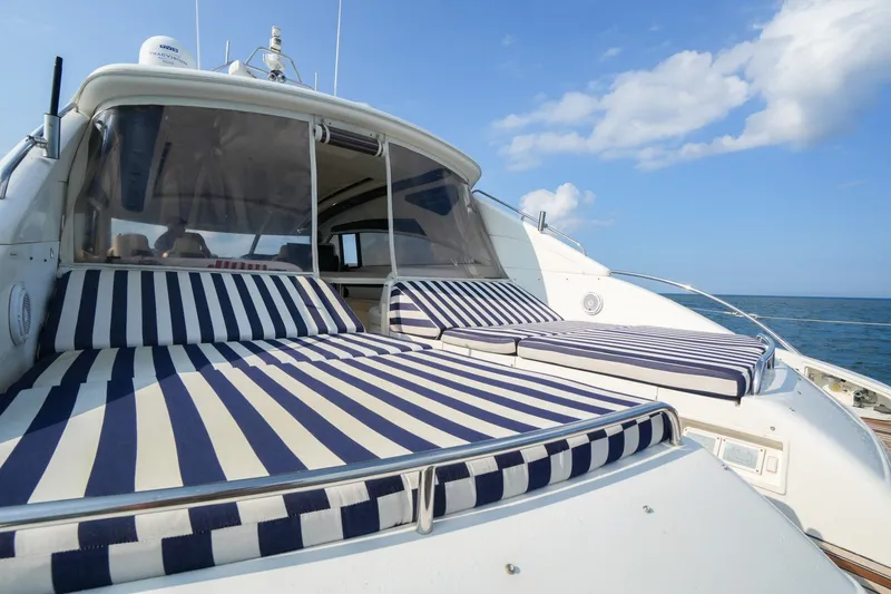 Slide: The Image of 2001 Viking Sport Cruisers V65 yacht with striped sunbeds on deck, ocean view. - 13
