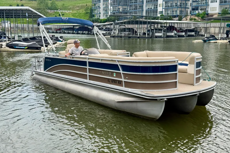 The Image of 2013 Harris Solstice 240 pontoon boat on a calm lake near a marina. - 1