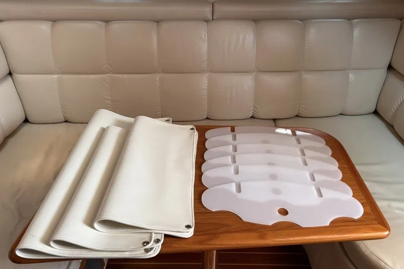 Slide: The Image of Interior of 1999 Tiara Yachts 3500 Open with white leather seating and wooden table. - 40