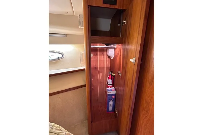 Slide: The Image of Wooden cabinet interior on a 1999 Tiara Yachts 3500 Open, featuring a fire extinguisher. - 43