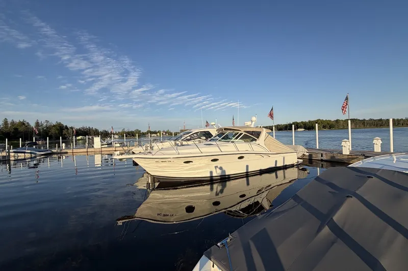 Slide: The Image of 1999 Tiara Yachts 3500 Open docked at a serene marina under clear blue skies. - 1