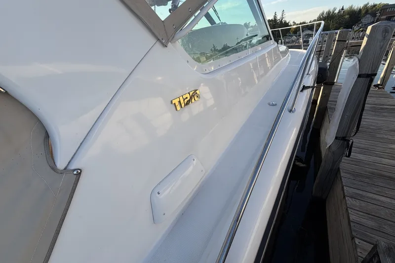 Slide: The Image of 1999 Tiara Yachts 3500 Open docked, showcasing sleek design and branding. - 8