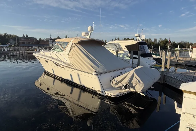 Slide: The Image of 1999 Tiara Yachts 3500 Open docked at marina, calm water reflection. - 4